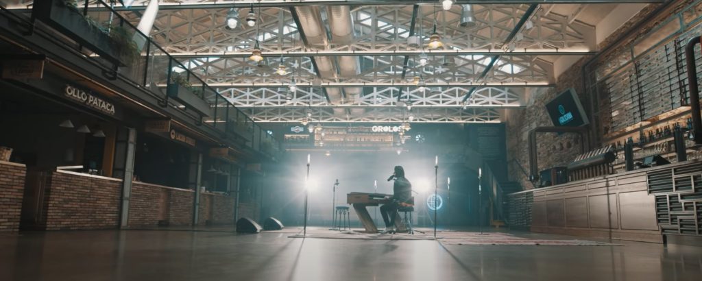 O músico Fredi Leis tocando o piano, plano do videoclip Nivel Experta